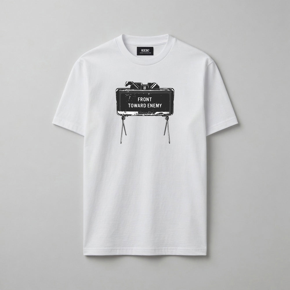 A white short-sleeve crewneck t-shirt with a graphic print of a Claymore Mine that reads 'FRONT TOWARD ENEMY' on the chest, displayed flat against a neutral grey background.