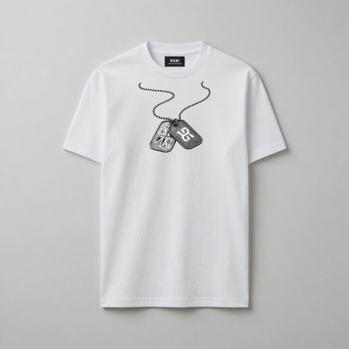 A white short-sleeve crewneck t-shirt featuring a black and grey graphic of military dog tags on a chain across the chest, displayed on a neutral grey background.