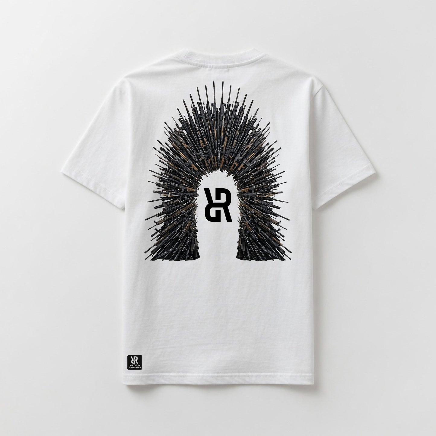 A white short-sleeve t-shirt shown flat against a light gray background, featuring a large graphic on the back with a central stylized 'R' logo surrounded by a crown-like spire of rifles. A small black 'R' logo patch is also visible near the bottom left hem.