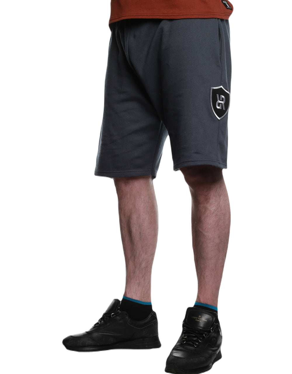 Front view of Charcoal REFLEKT Vanguard athletic shorts with large shield logo patch on the left side leg.