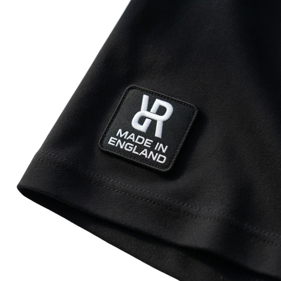 Black t-shirt with a REFLEKT 'Made in England' label on a white background