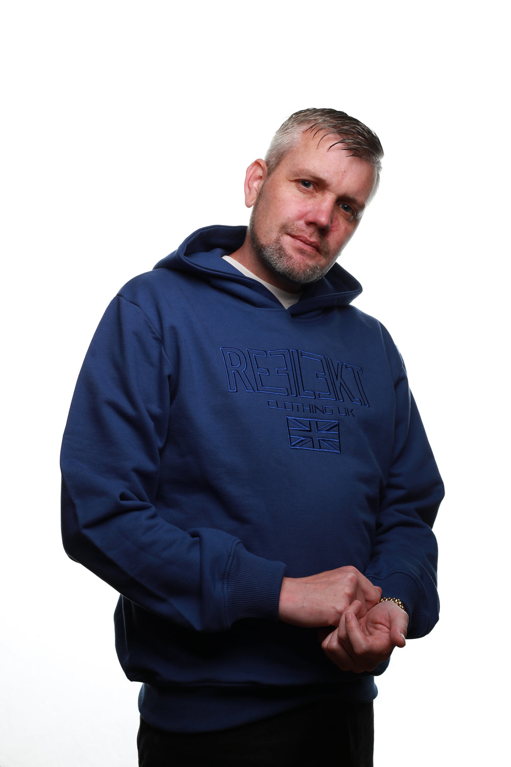 Side view of Navy British‑made REFLEKT Allegiance hoodie with front  embroidered branding.