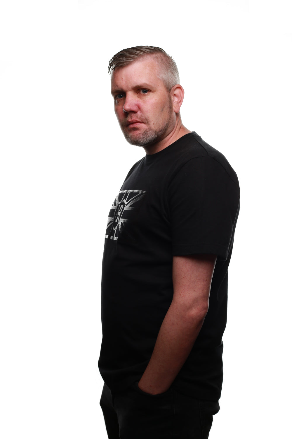 Side view of Black REFLEKT Legacy T‑shirt with tonal Union Jack graphic and shield logo on the chest.