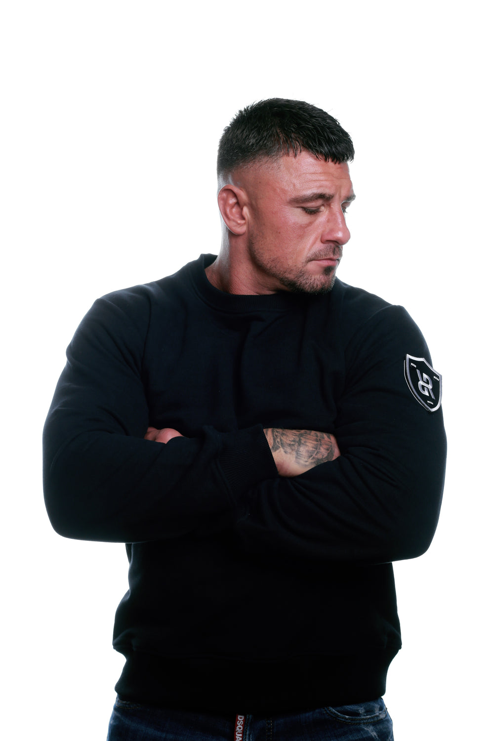 Front view of Black REFLEKT Legacy sweatshirt with shield logo patch on the left sleeve.