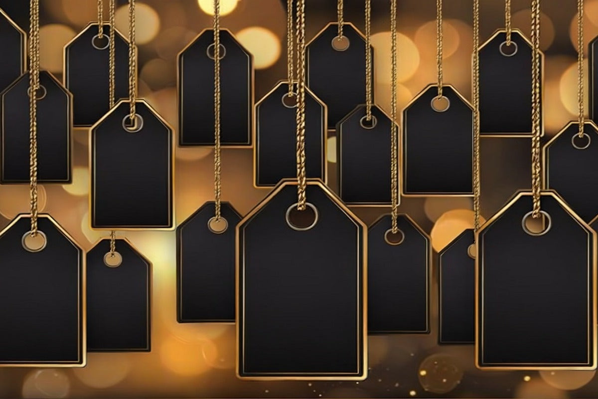 Black and gold sales tags hanging against a warm, blurred background