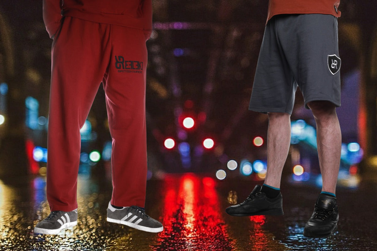 Two people standing on a wet street at night with colorful lights in the background